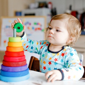Toddler stacking colorful rings in order of size