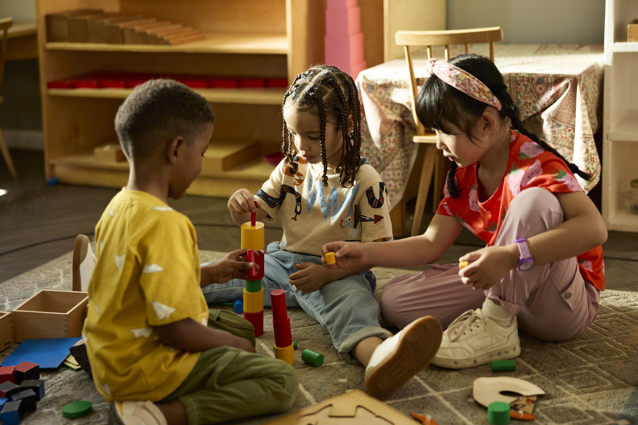 Friends playing with toy blocks in classroom